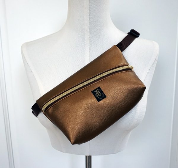 bronzefarbene Kunstlederhandtasche im Stil einer Bauchtasche.