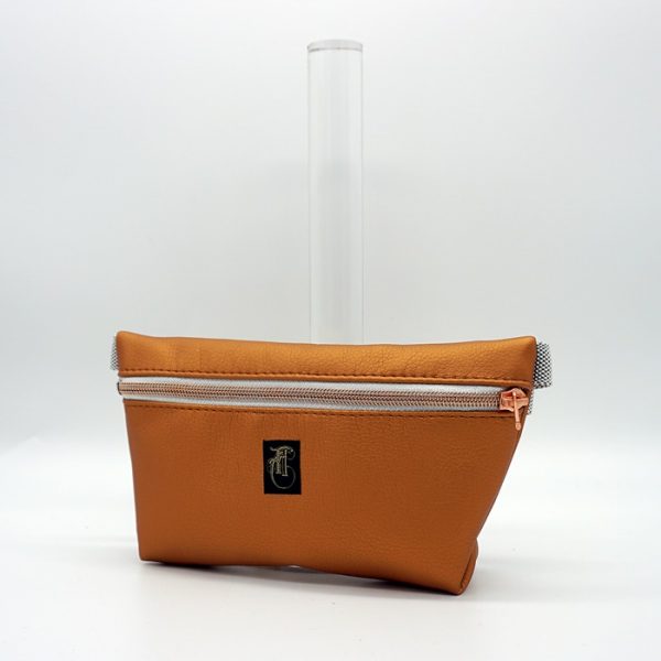 kupferfarbene Kunstlederhandtasche im Stil einer Bauchtasche.