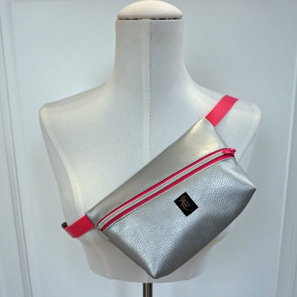 silberfarbene Kunstlederhandtasche im Stil einer Bauchtasche.